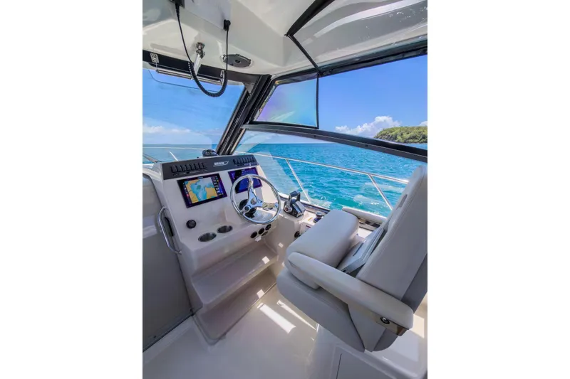 Slide: The Image of 2024 Boston Whaler 325 Conquest helm with ocean view, featuring modern navigation equipment. - 10