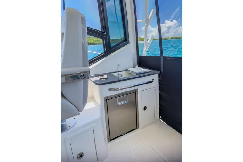 Slide: The Image of 2024 Boston Whaler 325 Conquest interior with kitchenette and ocean view. - 9
