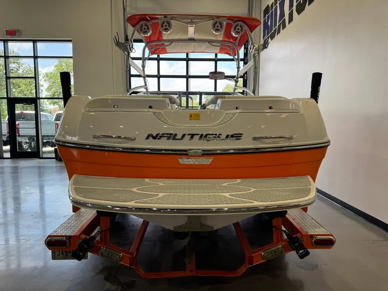 Slide: The Image of 2008 Nautique Super Air Nautique 230 in a showroom, orange and white. - 6