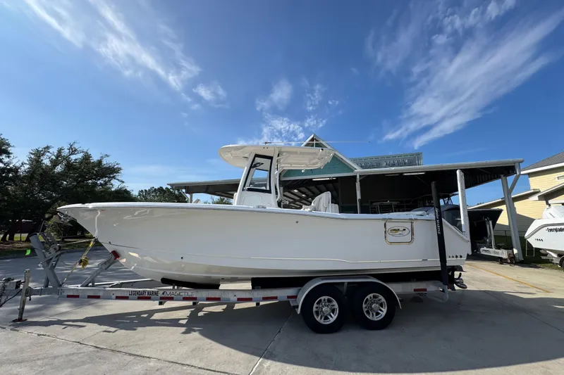 The Image of 2022 Sea Hunt Ultra 275 SE boat on trailer under clear blue sky. - 1