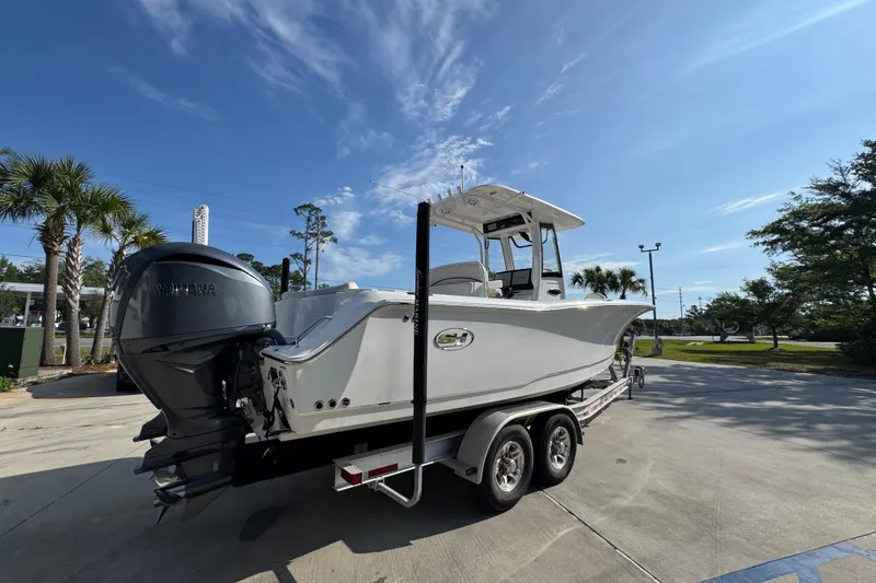 Slide: The Image of 2022 Sea Hunt Ultra 275 SE boat on trailer, parked outdoors under clear blue sky. - 10