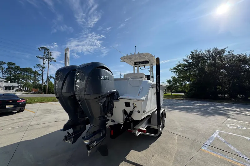 Slide: The Image of 2022 Sea Hunt Ultra 275 SE boat with dual Yamaha engines in a sunny parking lot. - 11