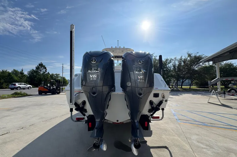 Slide: The Image of 2022 Sea Hunt Ultra 275 SE boat with dual Yamaha V6 outboard engines in a sunny parking lot. - 12