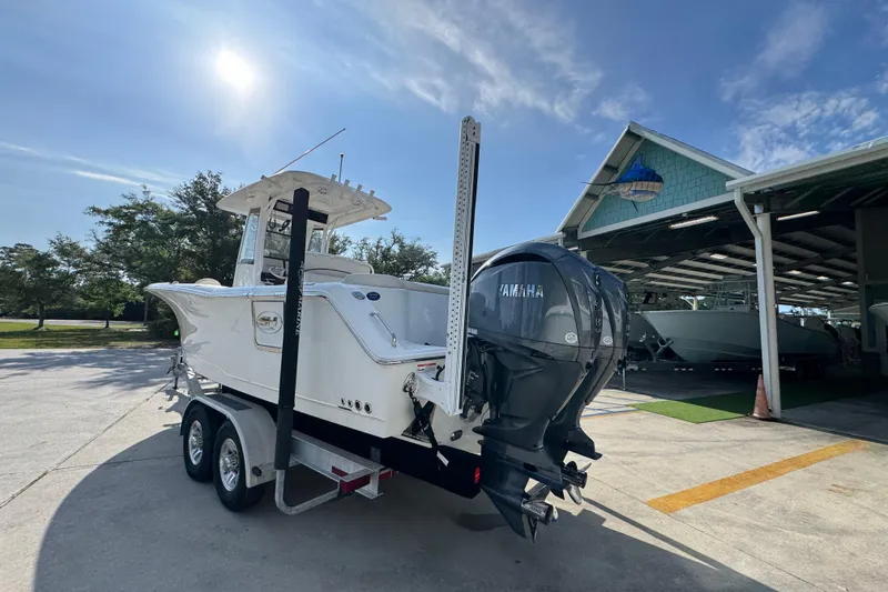 Slide: The Image of 2022 Sea Hunt Ultra 275 SE boat on trailer under sunny sky. - 13