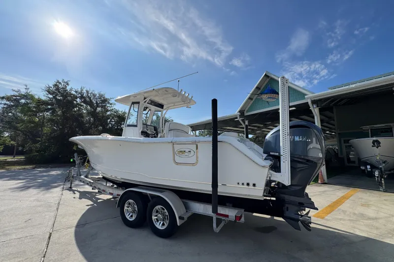 Slide: The Image of 2022 Sea Hunt Ultra 275 SE boat on trailer, parked outdoors under clear sky. - 14