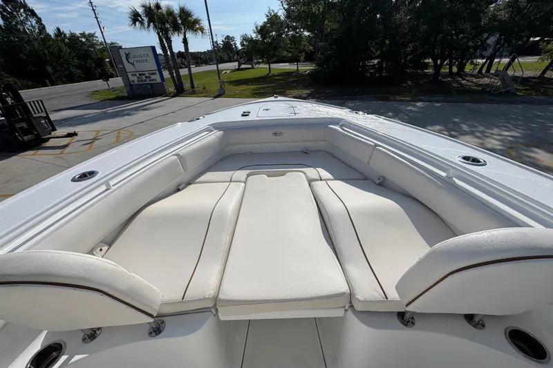 Slide: The Image of 2022 Sea Hunt Ultra 275 SE boat interior with white cushioned seating. - 16