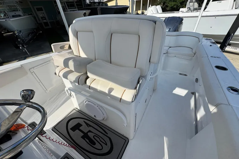 Slide: The Image of 2022 Sea Hunt Ultra 275 SE boat interior with white seating and steering wheel. - 22