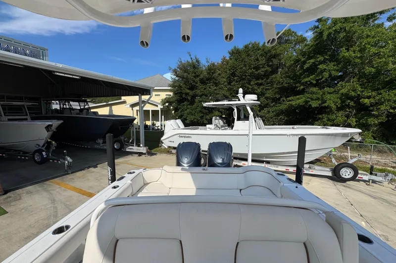 Slide: The Image of 2022 Sea Hunt Ultra 275 SE boat in marina, surrounded by other boats. - 24