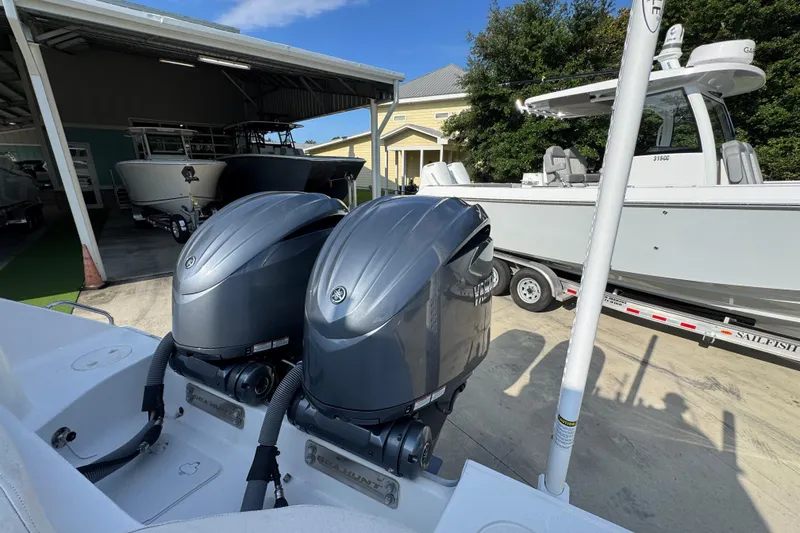 Slide: The Image of 2022 Sea Hunt Ultra 275 SE with dual outboard engines in a boatyard setting. - 34