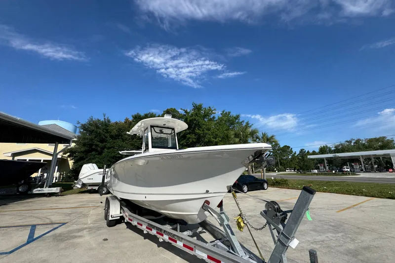 Slide: The Image of 2022 Sea Hunt Ultra 275 SE boat on trailer under clear blue sky. - 6