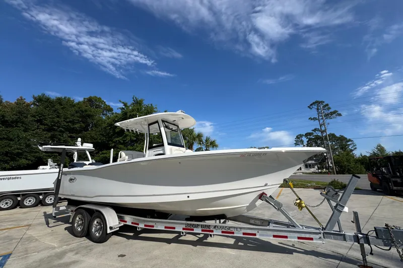 Slide: The Image of 2022 Sea Hunt Ultra 275 SE boat on trailer under clear blue sky. - 7