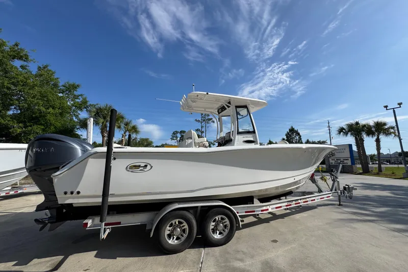 Slide: The Image of 2022 Sea Hunt Ultra 275 SE boat on trailer under clear blue sky. - 9