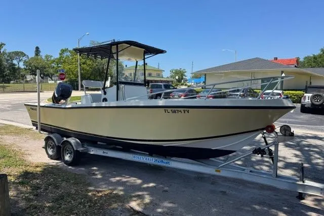 The Image of 1987 Mako 232 Center Console boat on trailer, parked outdoors in a sunny area. - 1