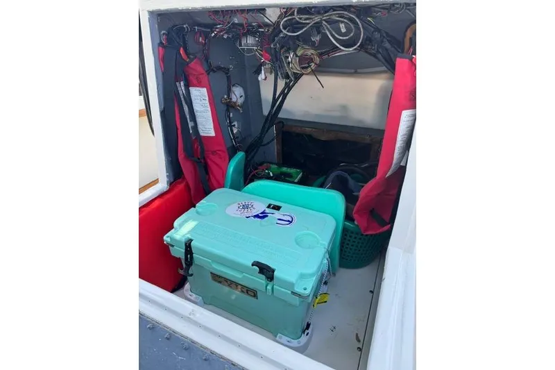 Slide: The Image of Interior of a 1987 Mako 232 Center Console boat with safety gear and cooler. - 11