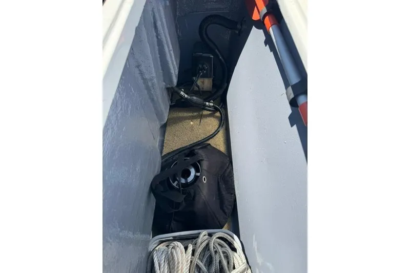 Slide: The Image of Storage compartment of a 1987 Mako 232 Center Console boat with ropes and equipment. - 19