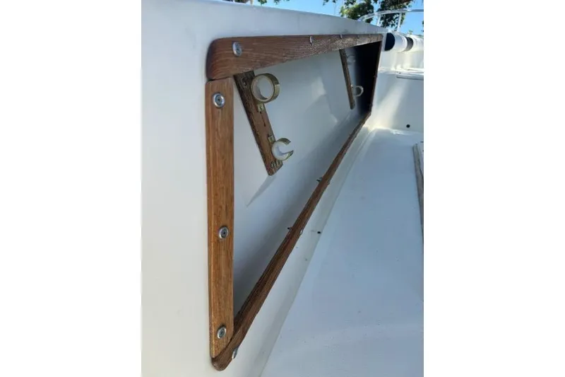 Slide: The Image of 1987 Mako 232 Center Console boat detail with wooden trim and metal fixtures. - 23