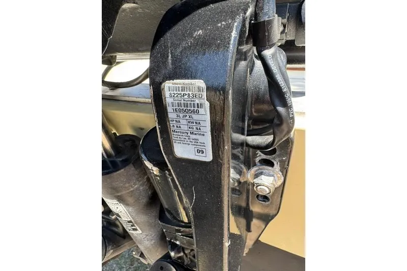 Slide: The Image of Close-up of a Mercury Marine engine part with serial number label on a 1987 Mako 232 Center Console. - 5
