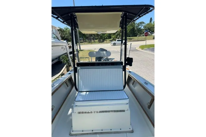 Slide: The Image of 1987 Mako 232 Center Console boat with seating and T-top in a parking area. - 8