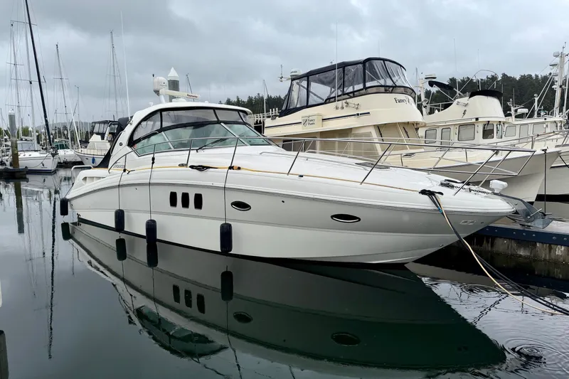 The Image of 2006 Sea Ray 38 Sundancer yacht docked in a marina on a cloudy day. - 0