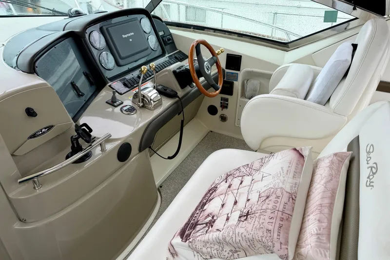 Slide: The Image of Helm of 2006 Sea Ray 38 Sundancer with plush seating and navigation controls. - 10