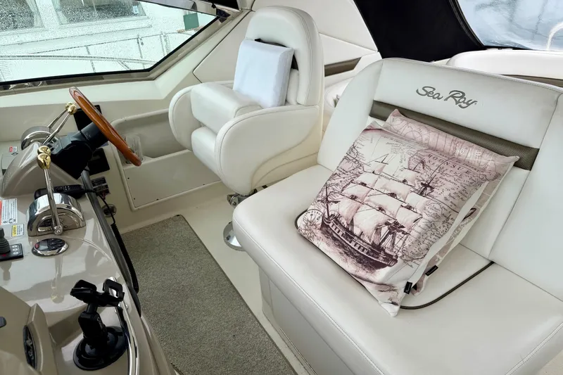 Slide: The Image of Interior of 2006 Sea Ray 38 Sundancer with nautical-themed pillow on white seating. - 11