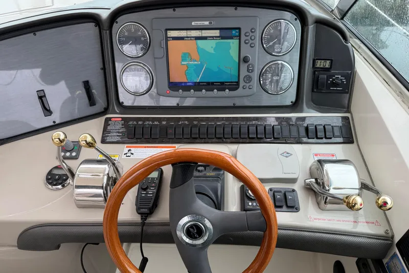 Slide: The Image of 2006 Sea Ray 38 Sundancer helm with navigation system and wooden steering wheel. - 14