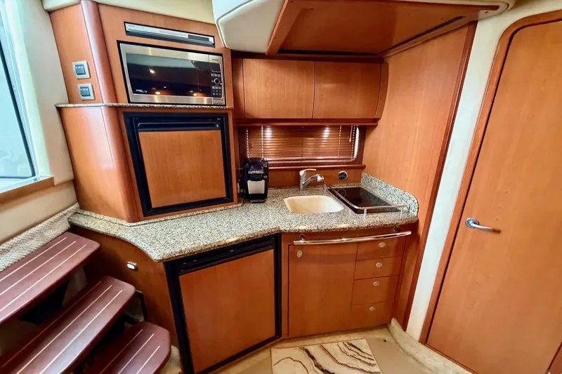 Slide: The Image of Luxurious 2006 Sea Ray 38 Sundancer yacht kitchen with wood cabinetry and granite countertops. - 20