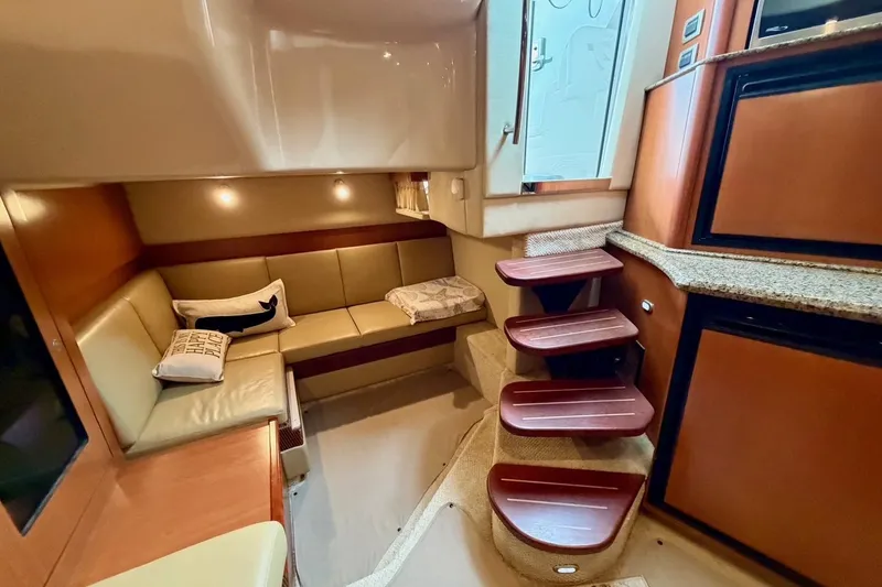 Slide: The Image of Interior of 2006 Sea Ray 38 Sundancer with cozy seating and elegant wooden steps. - 24