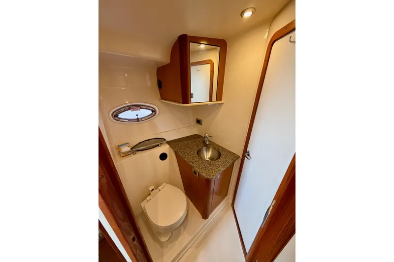 Slide: The Image of Luxurious 2006 Sea Ray 38 Sundancer yacht bathroom with sink, toilet, and mirror. - 28