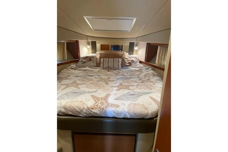 Slide: The Image of Cozy bedroom interior of 2006 Sea Ray 38 Sundancer yacht with patterned bedding. - 32