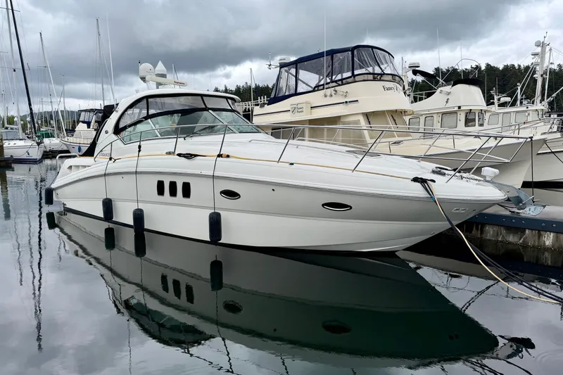 Slide: The Image of 2006 Sea Ray 38 Sundancer yacht docked in a marina under cloudy skies. - 47