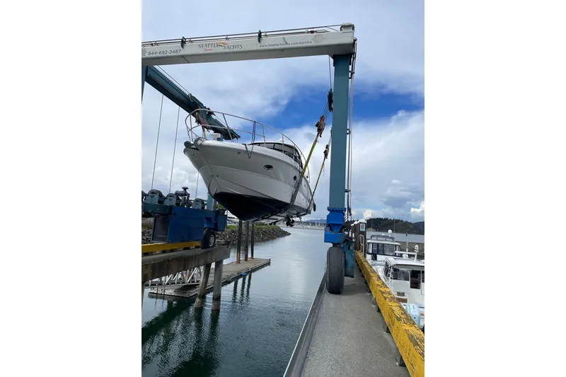 Slide: The Image of 2006 Sea Ray 38 Sundancer yacht being lifted by a crane at a marina. - 51