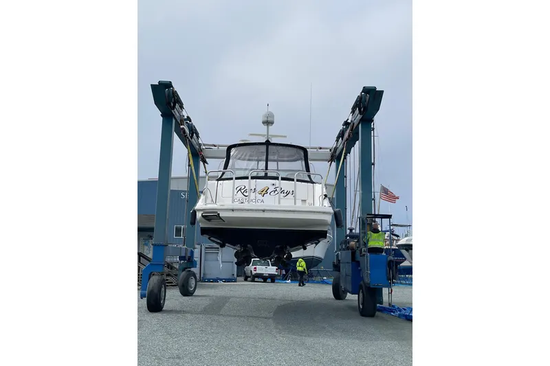 Slide: The Image of 2006 Sea Ray 38 Sundancer yacht being lifted at a marina with workers nearby. - 53