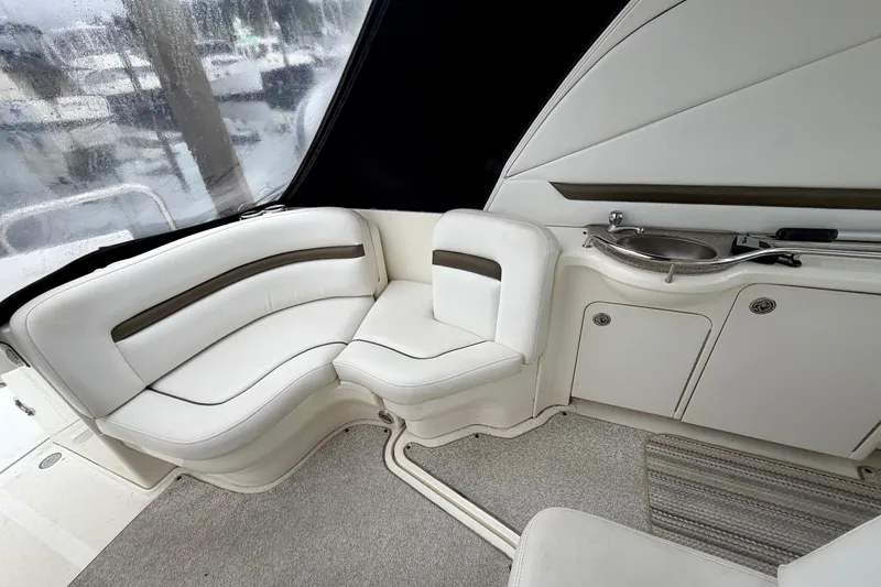 Slide: The Image of Interior of 2006 Sea Ray 38 Sundancer yacht with white seating and compact sink area. - 9