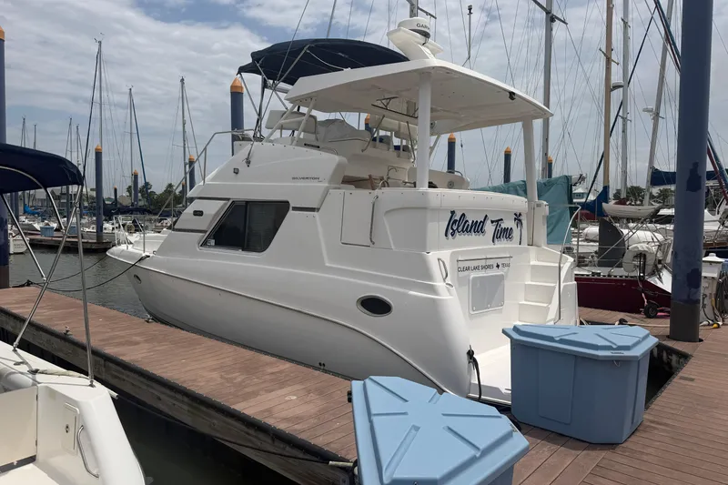 The Image of 1999 Silverton 352 Motor Yacht docked at marina, surrounded by sailboats. - 0
