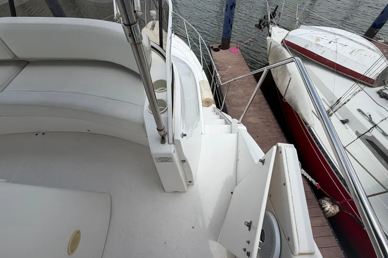 Slide: The Image of 1999 Silverton 352 Motor Yacht docked, featuring white seating and a view of the marina. - 10