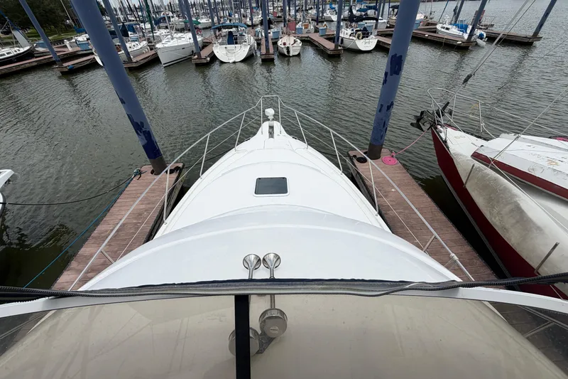 Slide: The Image of 1999 Silverton 352 Motor Yacht docked at marina, surrounded by sailboats. - 11