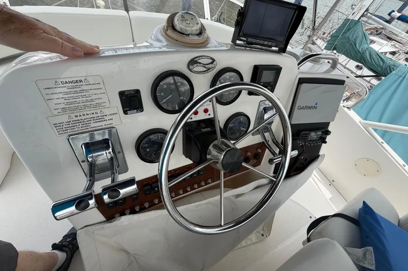 Slide: The Image of 1999 Silverton 352 Motor Yacht helm with steering wheel, gauges, and Garmin navigation system. - 13