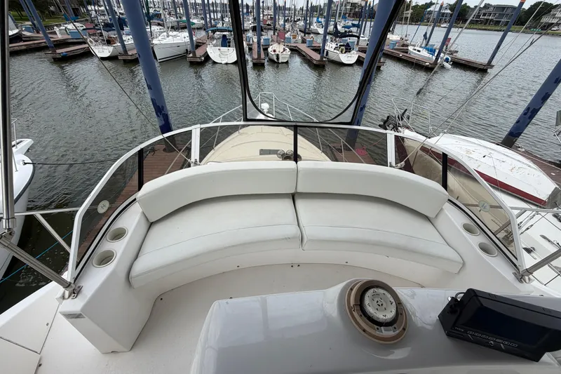 Slide: The Image of 1999 Silverton 352 Motor Yacht with white seating, docked at a marina. - 14