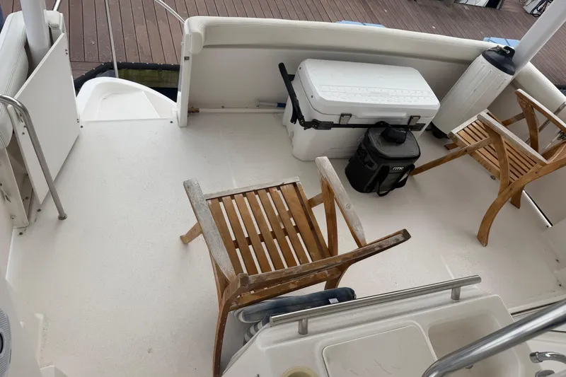 Slide: The Image of 1999 Silverton 352 Motor Yacht deck with wooden chairs and cooler. - 15