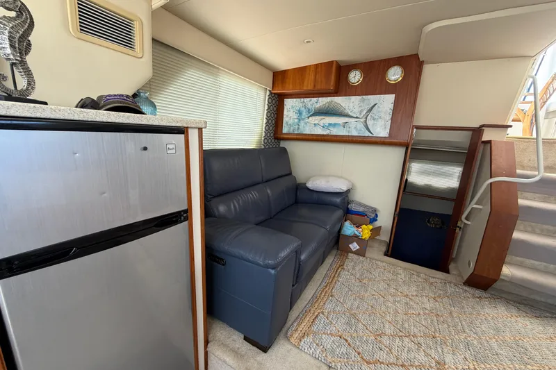 Slide: The Image of Interior of 1999 Silverton 352 Motor Yacht with sofa, fridge, and nautical decor. - 36