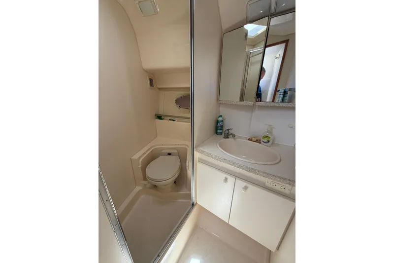 Slide: The Image of 1999 Silverton 352 Motor Yacht bathroom with toilet, sink, and mirrored cabinet. - 38