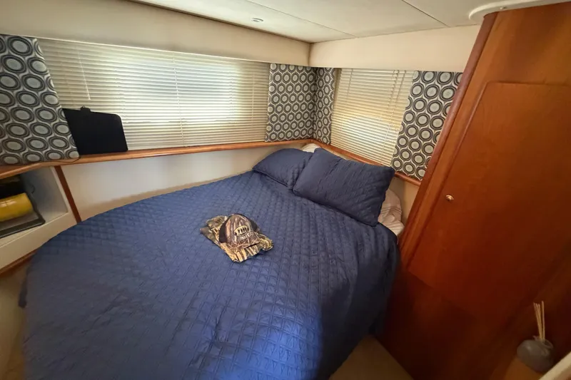 Slide: The Image of Cozy bedroom in 1999 Silverton 352 Motor Yacht with blue bedding and patterned curtains. - 39