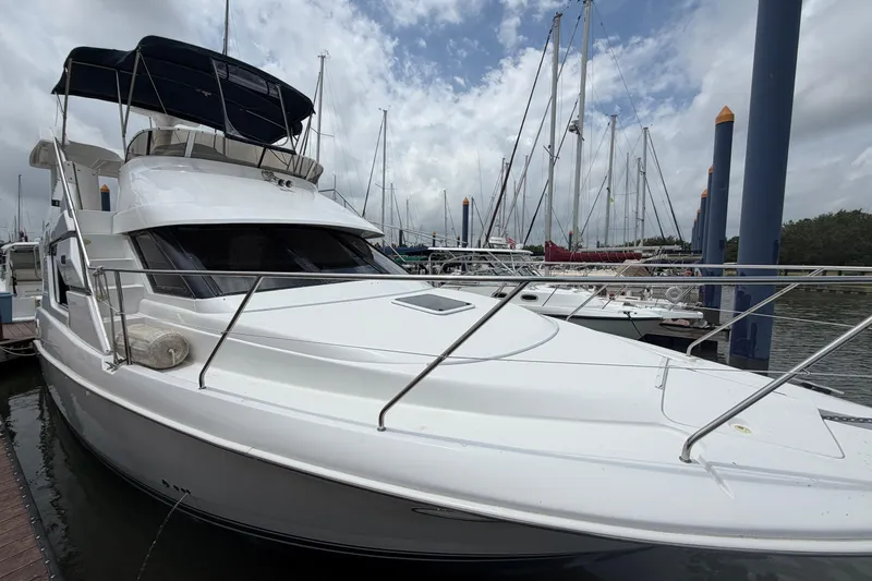 Slide: The Image of 1999 Silverton 352 Motor Yacht docked at marina under cloudy sky. - 4
