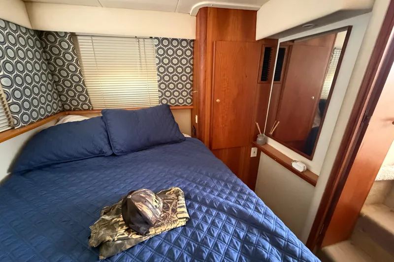 Slide: The Image of Cozy bedroom in 1999 Silverton 352 Motor Yacht with blue bedding and wooden accents. - 43