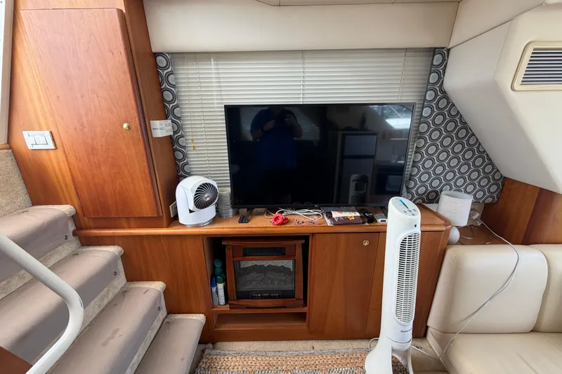 Slide: The Image of Interior of 1999 Silverton 352 Motor Yacht with TV, fan, and wooden cabinetry. - 47