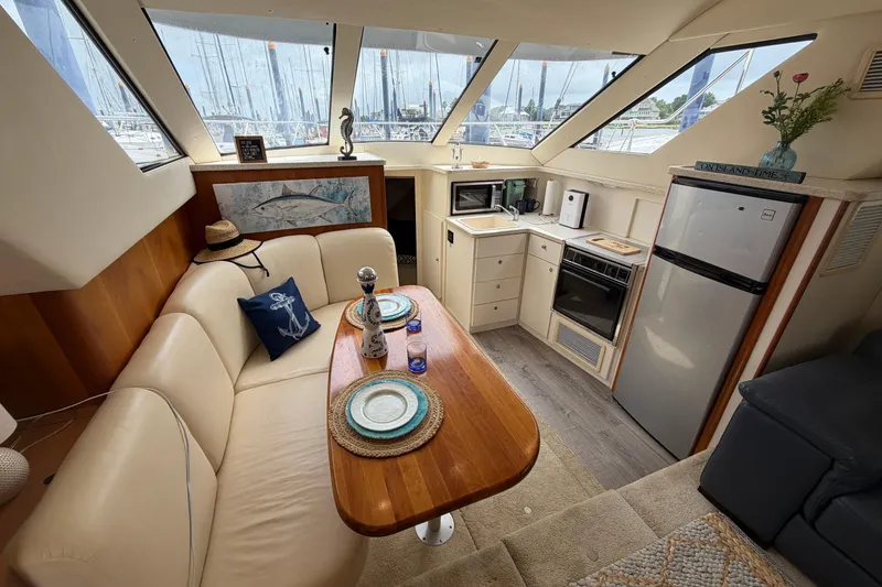 Slide: The Image of Interior of a 1999 Silverton 352 Motor Yacht with cozy seating and kitchenette. - 48