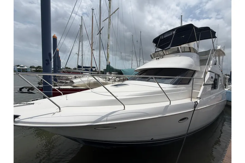 Slide: The Image of 1999 Silverton 352 Motor Yacht docked at marina under cloudy sky. - 5