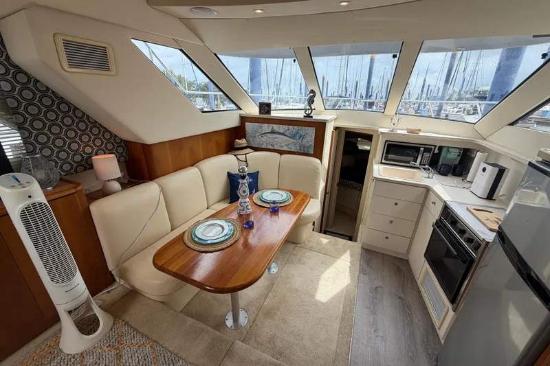 Slide: The Image of Interior of a 1999 Silverton 352 Motor Yacht with dining area and kitchen amenities. - 51
