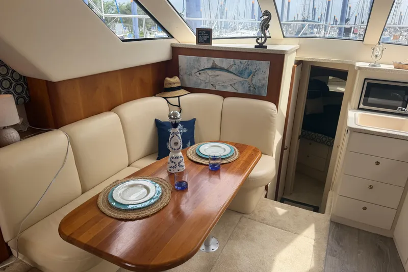 Slide: The Image of Interior of 1999 Silverton 352 Motor Yacht with cozy dining area and nautical decor. - 52